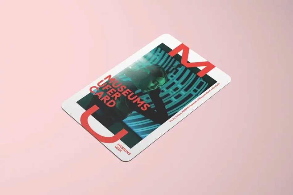 Die MuseumsuferCard mit einem Foto, auf dem eine junge Frau einen Kopfh&ouml;rer tr&auml;gt und sich mit den H&auml;nden an die Ohren fasst in dunklem Raum, auf rosa Hintergrund